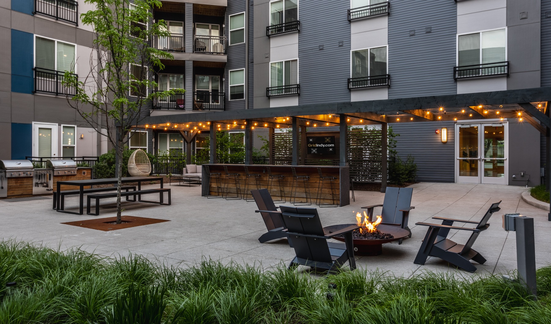 Grid apartments courtyard and fire pits at dusk